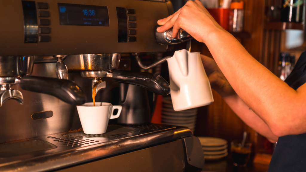 White cup being filled with decaf coffee in a cafe, a barista working